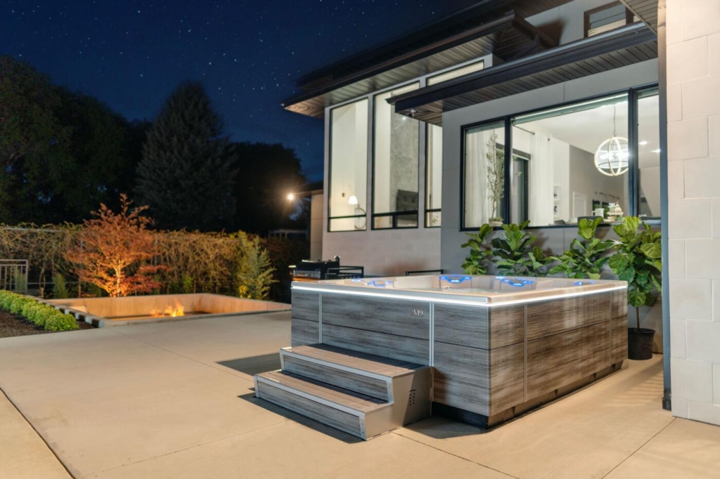 A bullfrog spa in the backyard of a modern home from Ashton Pools By Design. 