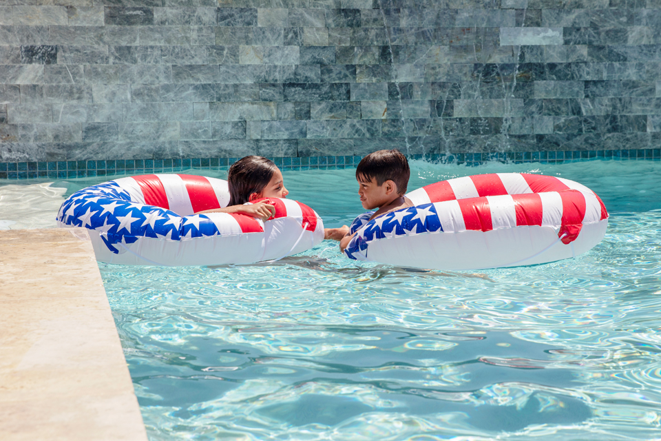 two kids floating in pool floats