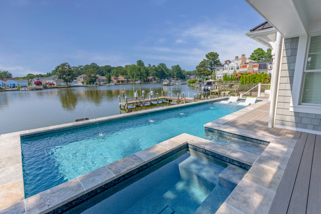 Custom concrete raised pool and spa with deck jets. 