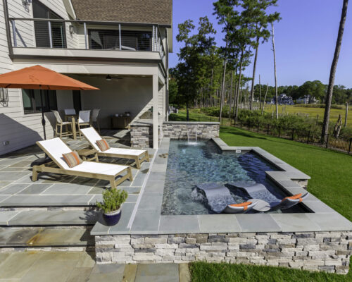Plunge pool with tanning ledge, spa jets, and waterfall for privacy
