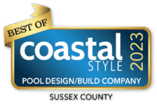 A blue and gold badge reads Best of Coastal Style 2023, Pool Design/Build Company, Sussex County—honoring excellence in luxury pools and inground pools.