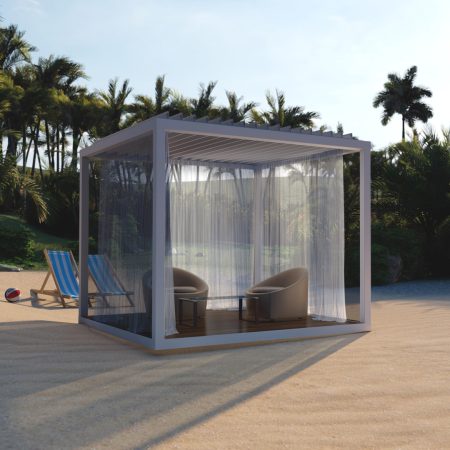 A modern cabana with sheer curtains contains two chairs and a small table on a sandy beach, perfect for outdoor living, with deck chairs and palm trees in the background.